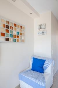 a white room with a bed with blue pillows at Coco cozy home in Pefkochori +11 photos