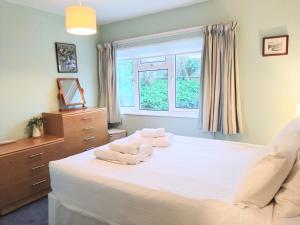 a bedroom with a bed with two towels on it at Waterwitch Cottage in Newquay