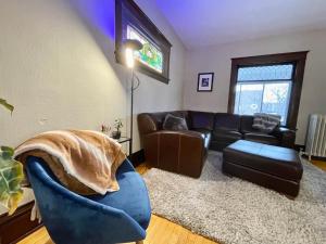 a living room with a couch and a blue chair at Charming Centrally Located Duplex with Parking in Minneapolis +10 photos