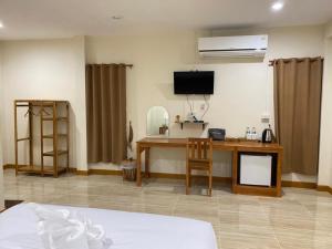 a hotel room with a desk and a television at น่านสุขใจ รีสอร์ท in Sa