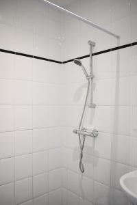 a shower in a white tiled bathroom with a sink at NEW Roof terrace apartment in Jordaan Area in Amsterdam