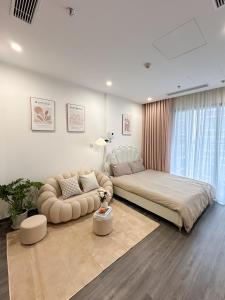 ein Schlafzimmer mit einem großen Bett und einer Couch in der Unterkunft Bunnys Homes - Vinhomes Ocean Park in Hanoi