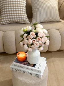 eine Vase mit Blumen auf einem Buch in der Unterkunft Bunnys Homes - Vinhomes Ocean Park in Hanoi + 54 Fotos