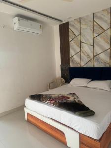 un letto in una stanza con un dipinto sul muro di Raj Palace a Ajmer