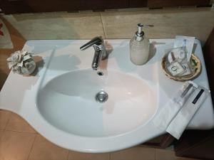 Un lavabo blanco con grifo en un baño. en B&B Vesuviano da zia Lella, en SantʼAnastasia 1 foto más