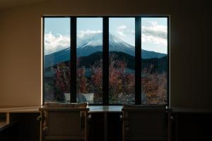 a view of a mountain through a large window at 富士山望むプライベートヴィラ 900平方メートルの敷地を貸切利用 憩 ikoi Fuji サウナ 4Kシアター in Fujikawaguchiko