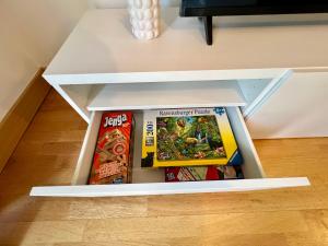 eine weiße Konsole mit Spielen darauf in der Unterkunft Cosy 2 Bed 2 Bath Apartment with Free Parking Smart TV Netflix and WIFI in Dartford 10 min to Bluewater in Dartford