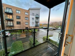 ein Balkon mit Blick auf ein Gebäude in der Unterkunft Cosy 2 Bed 2 Bath Apartment with Free Parking Smart TV Netflix and WIFI in Dartford 10 min to Bluewater in Dartford