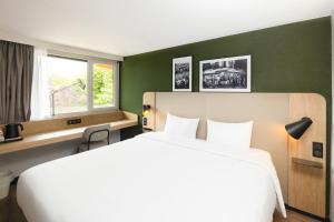 een hotelkamer met een groot bed en een raam bij Campanile NATURE Les Ulis in Les Ulis