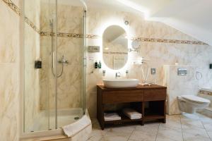 łazienka z prysznicem, umywalką i toaletą w obiekcie Hotel Horal w mieście Rožnov pod Radhoštěm