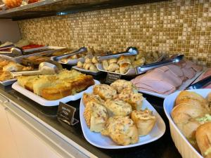 a buffet filled with different types of bread and pastries at Riviera Hotel by Bsb Inn in Brasília