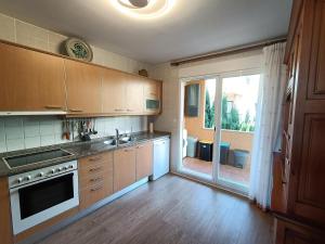 a kitchen with wooden cabinets and a large window at Chalet Estibaliz unifamiliar in Peniscola