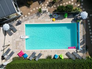 an overhead view of a swimming pool with chaises and chairs at Gites les volets rouges d'Allonnes in Allonnes