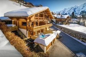 a large wooden house with snow on top of it at Chalet des Enfants La Clusaz - OVO Network in La Clusaz +17 photos