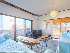 a living room with a couch and a table at 九十九里PARK GARDENー寛道ー in Ichinomiya