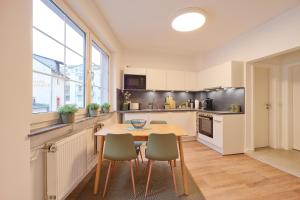 a kitchen with a wooden table and chairs at NEU - Stilvolle & zentrale Ferienwohnung mit Komfort in Wittlich - Zentrum - 4 Personen - 2 Schlafzimmer - Netflix - Waschmaschine in Wittlich
