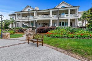 ławka siedząca przed dużym domem w obiekcie 1838 Beachside Tennis w mieście Hilton Head Island