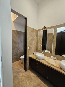 a bathroom with two sinks and two mirrors at Girardot Casa estilo mediterraneo con piscina privada in Girardot