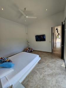 a bedroom with a large white bed and a flat screen tv at Girardot Casa estilo mediterraneo con piscina privada in Girardot