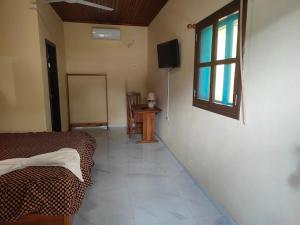 a bedroom with a bed and a window and a television at Residencial do Chocolate - CECAB in Guadalupe