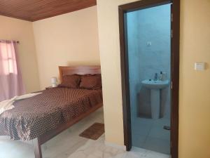 a bedroom with a bed and a bathroom with a sink at Residencial do Chocolate - CECAB in Guadalupe