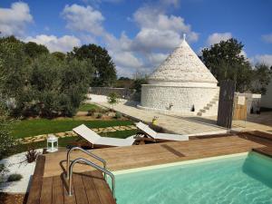 a house with a swimming pool and a pyramid at La Relais del Trullo in Putignano