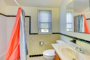 a bathroom with a toilet and a sink and a mirror at DC Area Home 1 Mi to Light Rail! in Wheaton