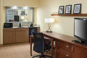 ein Hotelzimmer mit Schreibtisch und Fernseher in der Unterkunft Courtyard by Marriott Jackson Ridgeland in Jackson