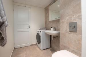 a bathroom with a sink and a washing machine at 2 bedroom Family Apartment near Spa Tervise Paradiis in Pärnu +15 photos