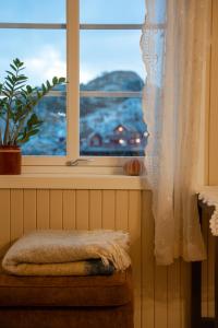 a window with a towel on a stool in front of a window at Anitas Waterfront Cabins in Reine +86 photos