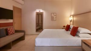 a bedroom with a large white bed and a couch at Calaserena Resort in Geremèas
