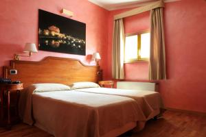 a bedroom with a large bed and a painting on the wall at Hotel Kent in Rome