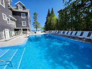 a swimming pool with chairs and a house at North Shore Inn TC 102 in Traverse City