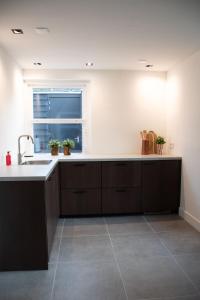 a large kitchen with a sink and a window at B&B de Vaert in Kaatsheuvel