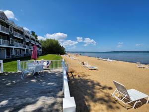 a beach with chairs and tables and a building at North Shore Inn TC 302 in Traverse City