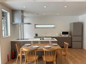 a kitchen with a table with chairs and a sink at Kokoro House Misorano in Hakuba