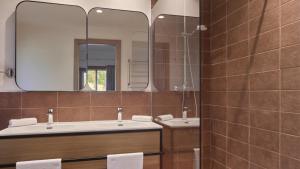 a bathroom with two sinks and a mirror at Calaserena Resort in Geremèas