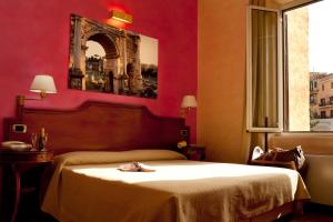 a red bedroom with a bed with a robe on it at Hotel Kent in Rome