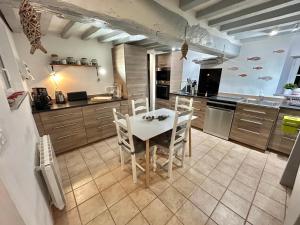 a kitchen with a white table and chairs in it at Longère Normande in Sainte-Marguerite