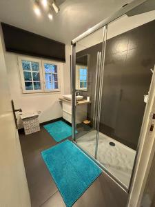 a bathroom with a shower and two blue mats at Longère Normande in Sainte-Marguerite