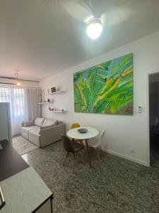 a living room with a table and a couch at Espaçoso e iluminado, 1 quadra da praia, ar condicionado in Rio de Janeiro