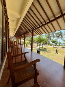 a porch with chairs and a view of a park at Arys Lagoon Bungalow & Hotel in Karimunjawa