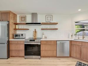 eine Küche mit Holzschränken und Geräten aus Edelstahl in der Unterkunft Charming Two-King-bedroom house in delightful Naples in Naples