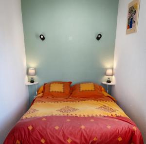 ein Schlafzimmer mit einem Bett mit roter Bettwäsche und zwei Lampen in der Unterkunft Maison Les Rives de la Tour Aigues-Mortes - Proche des remparts - Idéalement situé in Aigues-Mortes