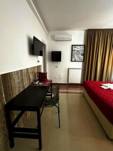 a hotel room with a bed and a desk in a room at Abside Suite & Spa in Palermo