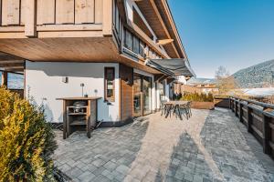 a patio of a house with a table and chairs at See das Ferienhaus in Oetz