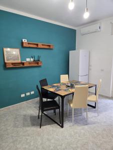a dining room with a table and chairs and a blue wall at Family Home Casa Vacanze in Portici