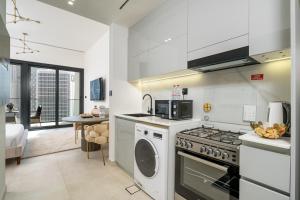 a kitchen with a stove and a washer and dryer at Business Bay Studio Binghatti Canal with Terrace in Dubai