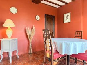 a dining room with orange walls and a table and chairs at La Renaissance in Bayeux