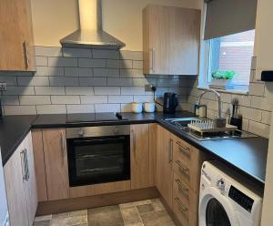 een keuken met een kookplaat, een oven en een vaatwasser bij Civic Heights in Newport